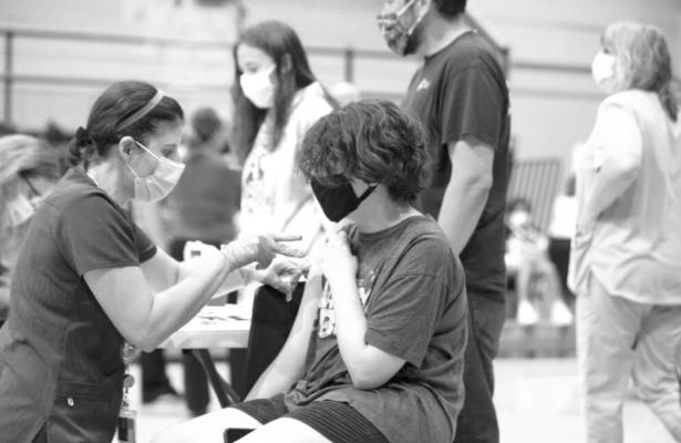 A 12-year-old student receives a COVID-19 vaccine during a clinic in August at Topeka High School. The Safer Classrooms Workgroup wants schools to encourage younger kids to get vaccinated as soon as federal regulators provide a green light. (Pool photo by Evert Nelson/The Capital-Journal)