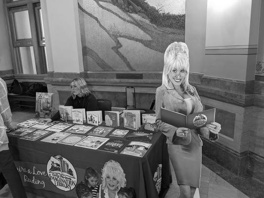 Gov. Laura Kelly signed bipartisan legislation creating a new K-12 and university program to improve reading literacy. The image is of supporters of Dolly Parton’s Imagination Library hosting a table inside the Kansas Capitol. (Tim Carpenter/Kansas Reflector)